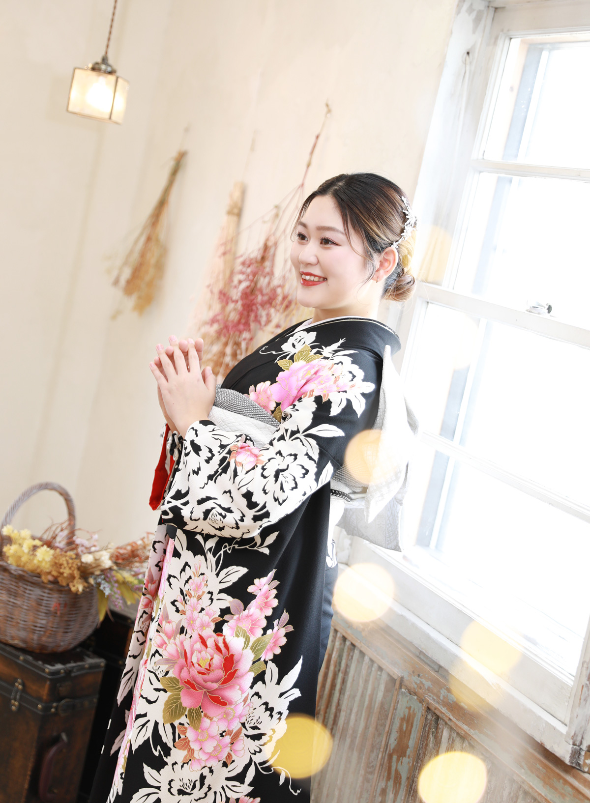 黒地にピンクの花柄振袖で窓辺の撮影